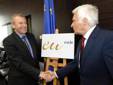 Yves Leterme y Jercy Buzek s saludan ante el logo de la presidencia belga