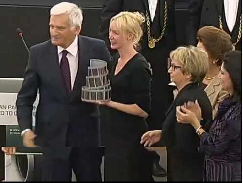 La directora posa con el premio en la mano al lado del presidente del Parlamento