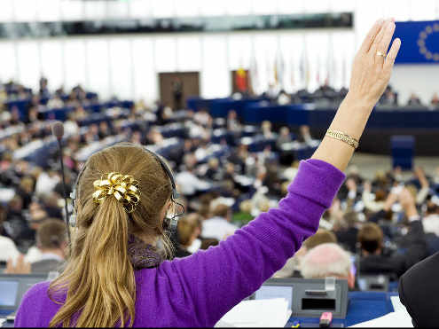 una parlamentaria levanta la mano para votar