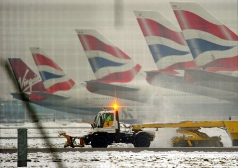 las colas de cinco aviones con la bandera de Reino Unido sobre una pista nevada