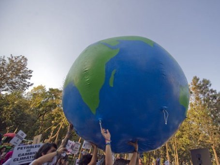 manifestantes de Greenpeace con un globo del mundo