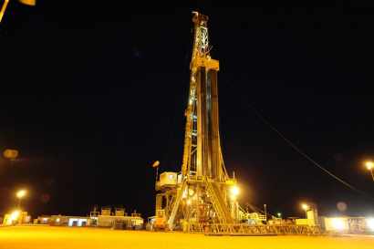 pozo de petróleo iluminado en la noche