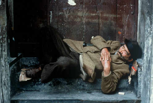 Un hombre durmiendo entre cartones