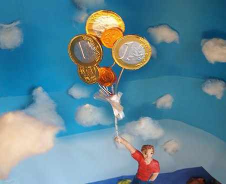 en el dibujo un niño sujeta una montón de globos en los que hay la imagen del euro