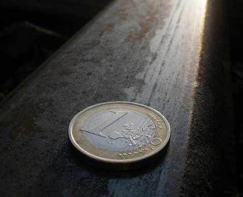 moneda de un euro en el suelo iluminada con un foco