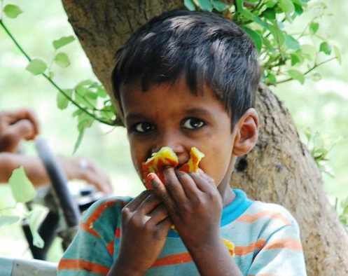 un niño comiendo una fruta