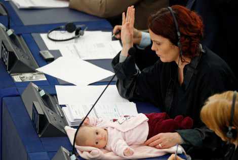 Una mujer en su puesto de trabajo con un bebé