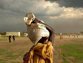 una mujer con un saco de grano en la cabeza