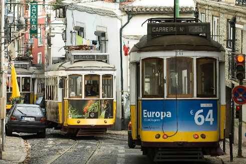 Dos tranvías se cruzan en una calle lisboeta, en uno de ellos pone Europa