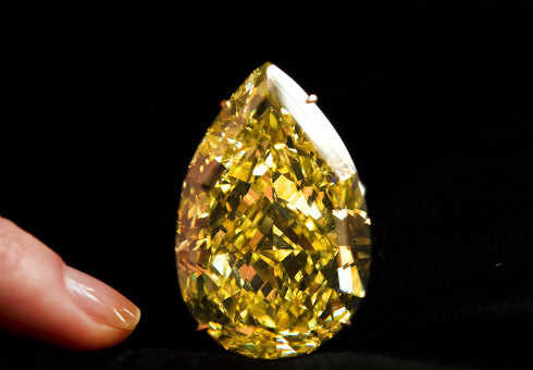 Un dedo señala el diamante de un amarillo brillante