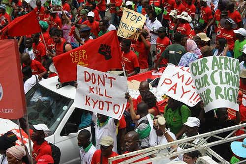 Manifestantes con carteles a favor de prolongar el protocolo de Kioto