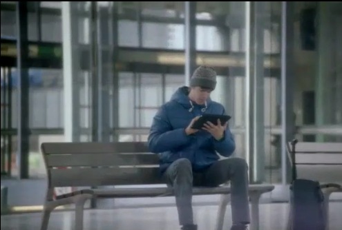 Un jóven en una sala de espera de aeropuerto con una tableta