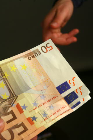 Dos manos diferentes intercambian billetes de 50 euros