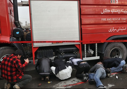 Un grupo de periodistas parapetados tras un camión