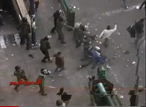 Policías pegan a un hombre en el suelo