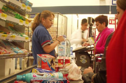 Mujer atiende la caja de un supermercado