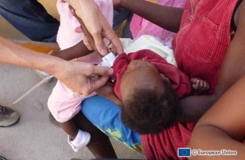 Un médico atiende a un bebé en brazos de su madre