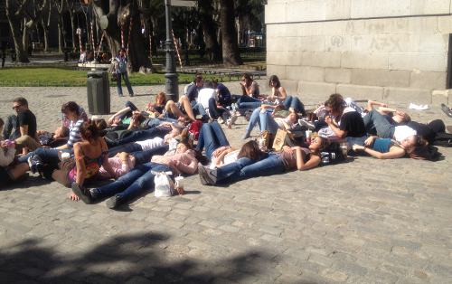 Jóvenes españoles tumbados en la calle