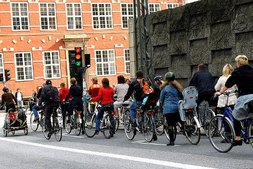 Un grupo numeroso de personas en bicicletas esperando en un semáforo