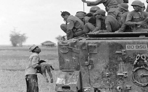 Un hombre muestra el cadáver de su hijo a soldados vietnamitas