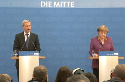 Norbert Röttgen y Angela Merkel, ante la prensa