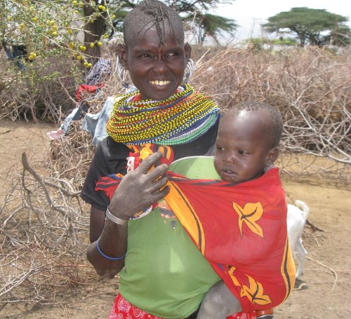 Una mujer keniata embarazada con un bebé en brazos