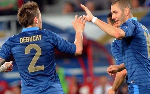 Los jugadores franceses Benzema y Debuchy se saludan en un partido