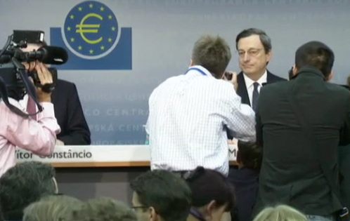 Mario Draghi en la sala de prensa rodeado de fotógrafos 