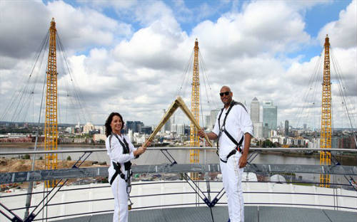 John Amaechi y Nadia Comaneci con la llama olímpica en el Greenwich Arena