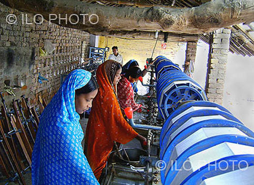 Jóvenes indias trabajan en la manufactura de seda