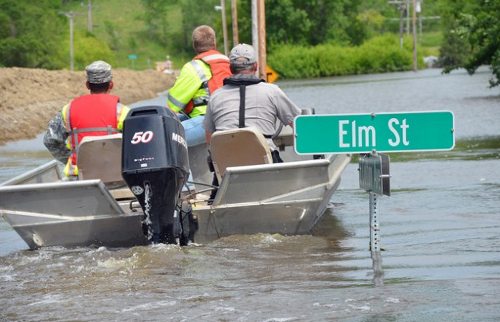 Unos hombres en una barca por una calle inundada