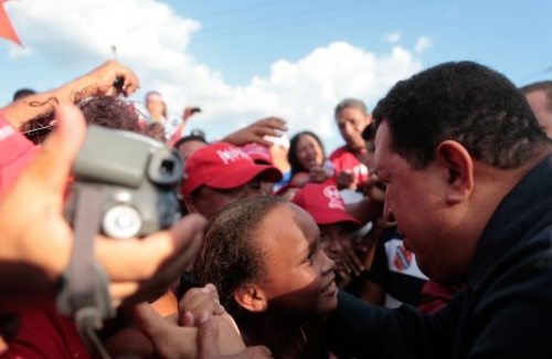Hugo Chávez saluda a una niña entre una multitud