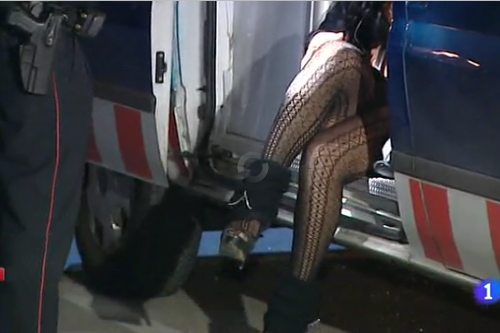 Las piernas de una prostituta sentada en un coche de policía
