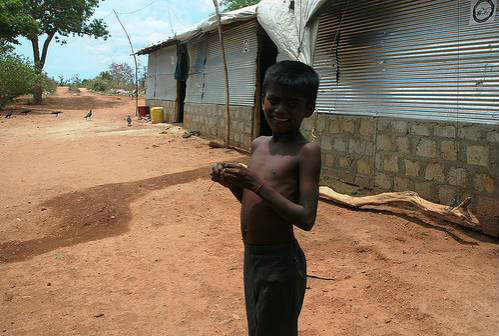 Niño en Sri-Lanka ante la puerta de su cabaña