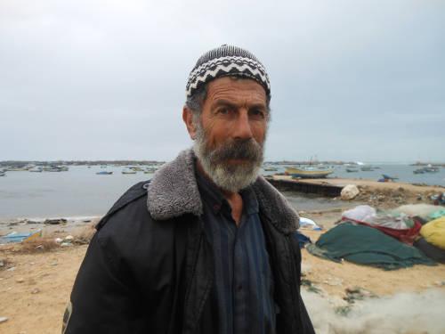 Mohamed Baker, pescador gazatí junto a unas barcas