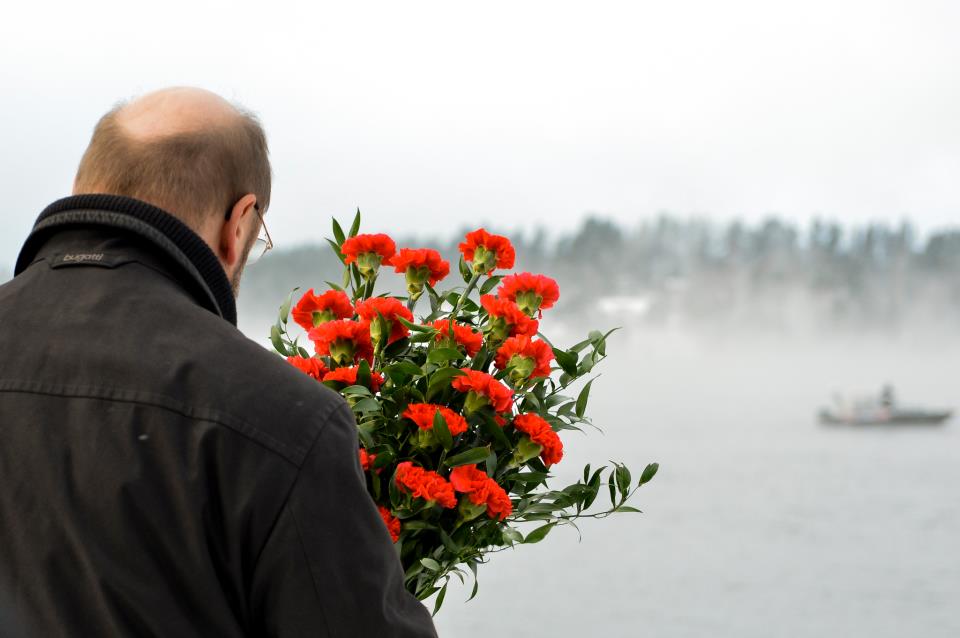 El presidente del Parlamento con un ramo de flores ante el lago