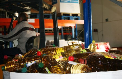 Un voluntario traslada botellas de aceite