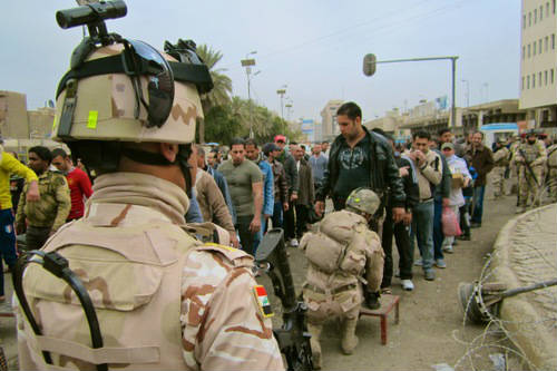 Soldados cacheando a ciudadanos iraquíes