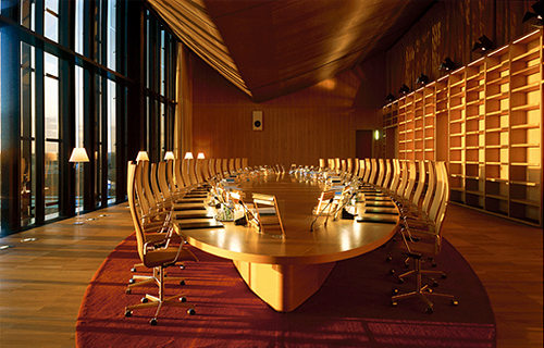 Una enorme sala con una mesa ovalada y sillones