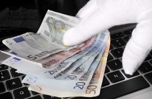 Una mano con guante blanco muestra billetes de euro