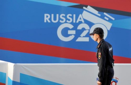 Un policía pasa delante del logo del G20