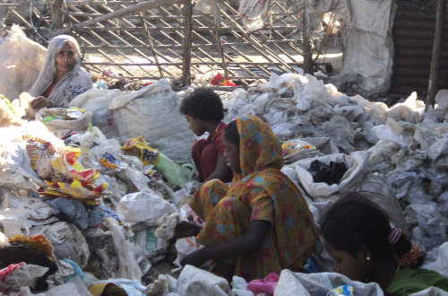 Mujeres sentadas en el suelo entre gran cantidad de bolsas de plástico