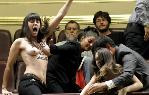 Activistas con el torso desnudo empujadas por los ujieres