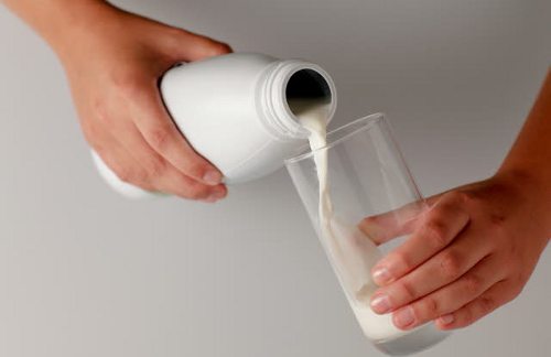 Una persona llena un vaso de leche