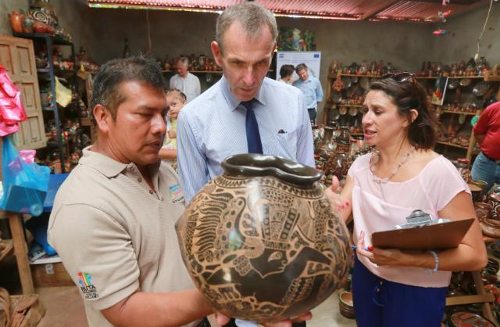 Un profesor enseña al comisario una vasija de cerámica