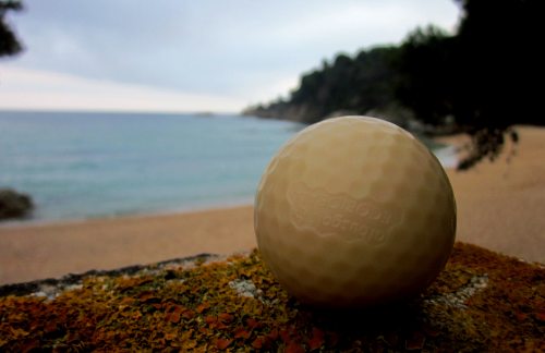 Una bola de golf, al fondo el mar
