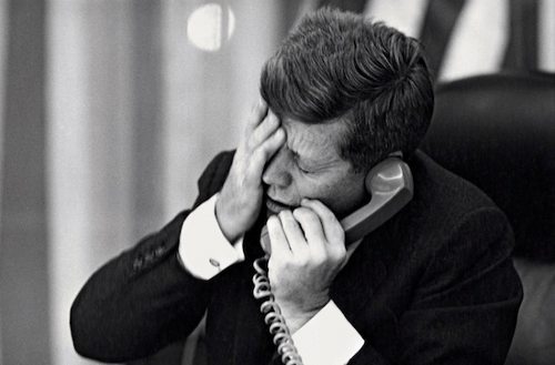Kennedy habla por teléfono mientras se pasa una mano por la cara