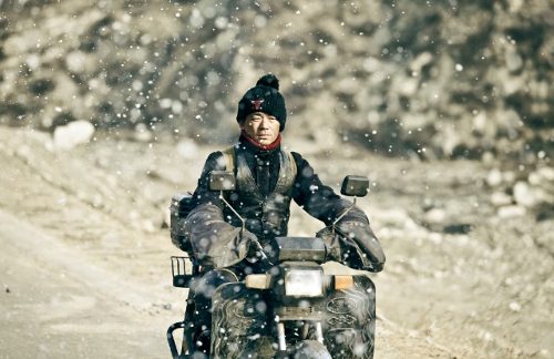 Un hombre en moto bajo una fuerte nevada