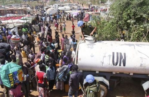 Personal civil espera turno para recoger agua ante cisternas de la ONU