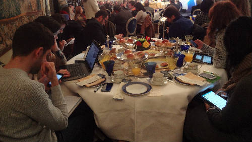 Grupo de personas en una mesa conectados a dispositivos móviles